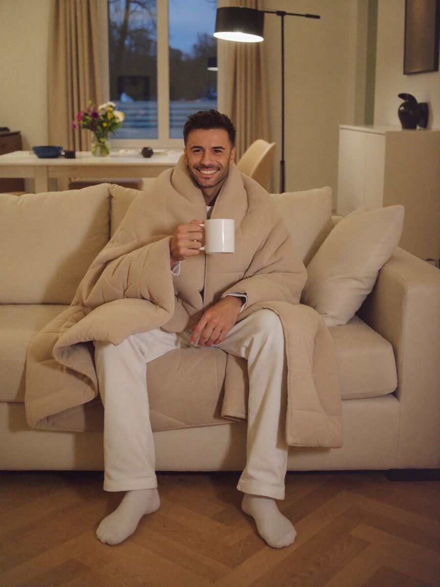 Adnan, Gründer von Heavy Sheep, auf dem Sofa in seine Decke gewickelt